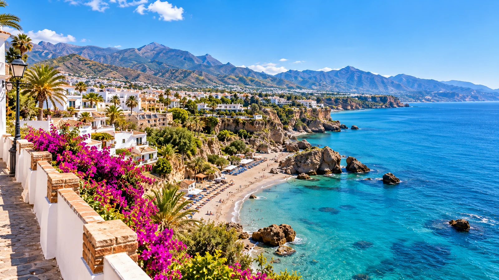 Scenic Costa del Sol cove with white hillside homes, flowers and rugged Mediterranean coastline.